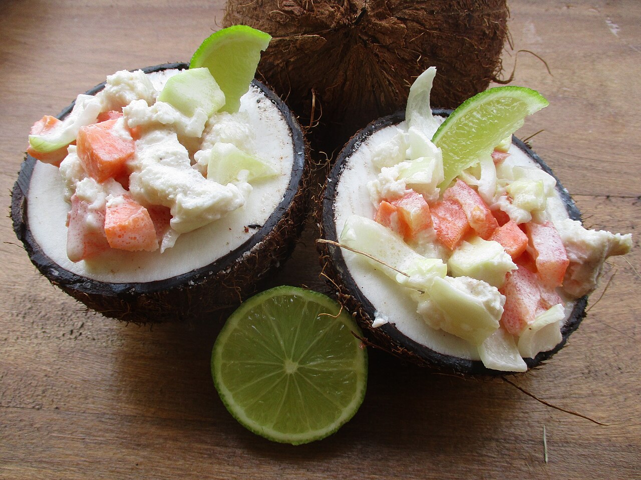 Real photograph of ika mata with raw fish, coconut cream and vegetables served in coconut shells